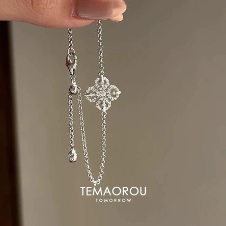 New Chinese-style silver bracelet featuring a sparkling four-leaf clover/cross-vajra motif; a "Chanel-esque" design perfect for layering.